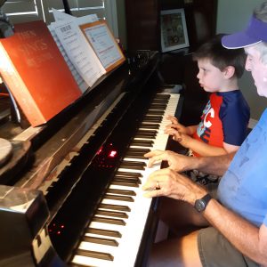Terry playing piano with grandson